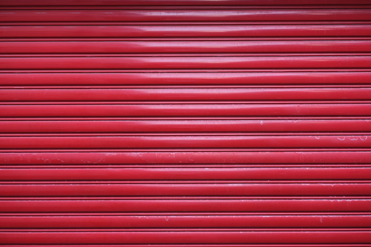 Close-up of red metal roll-up door showcasing a textured industrial design.